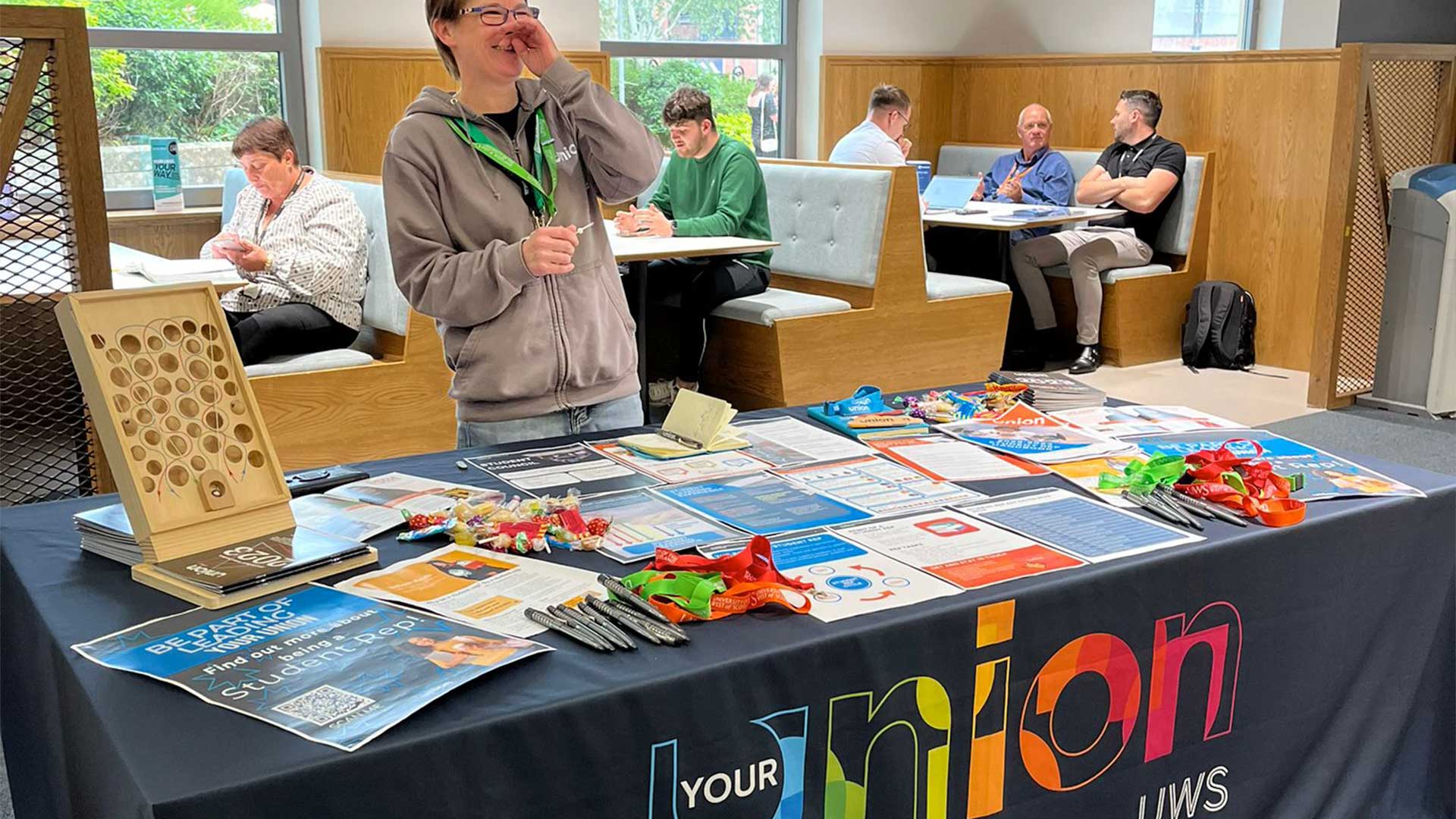 A staff member laughing at a Union UWS branded stall